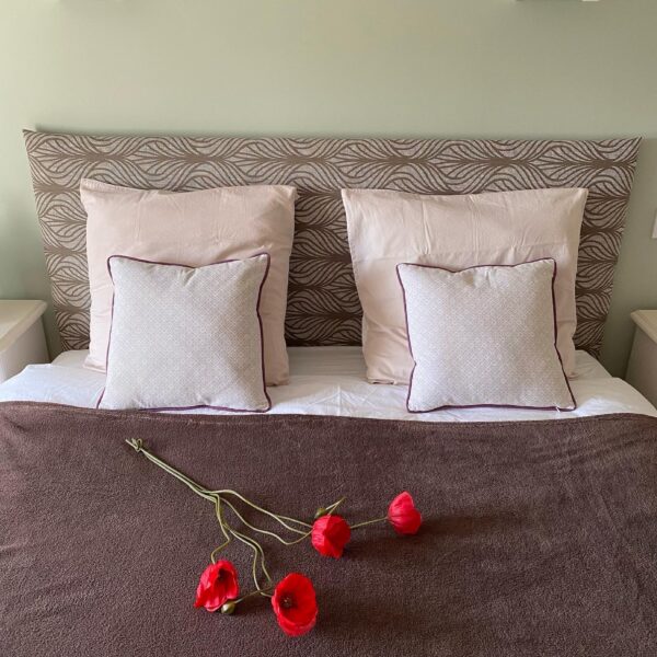 Tête de lit sur-mesure en tissu sur support bois.